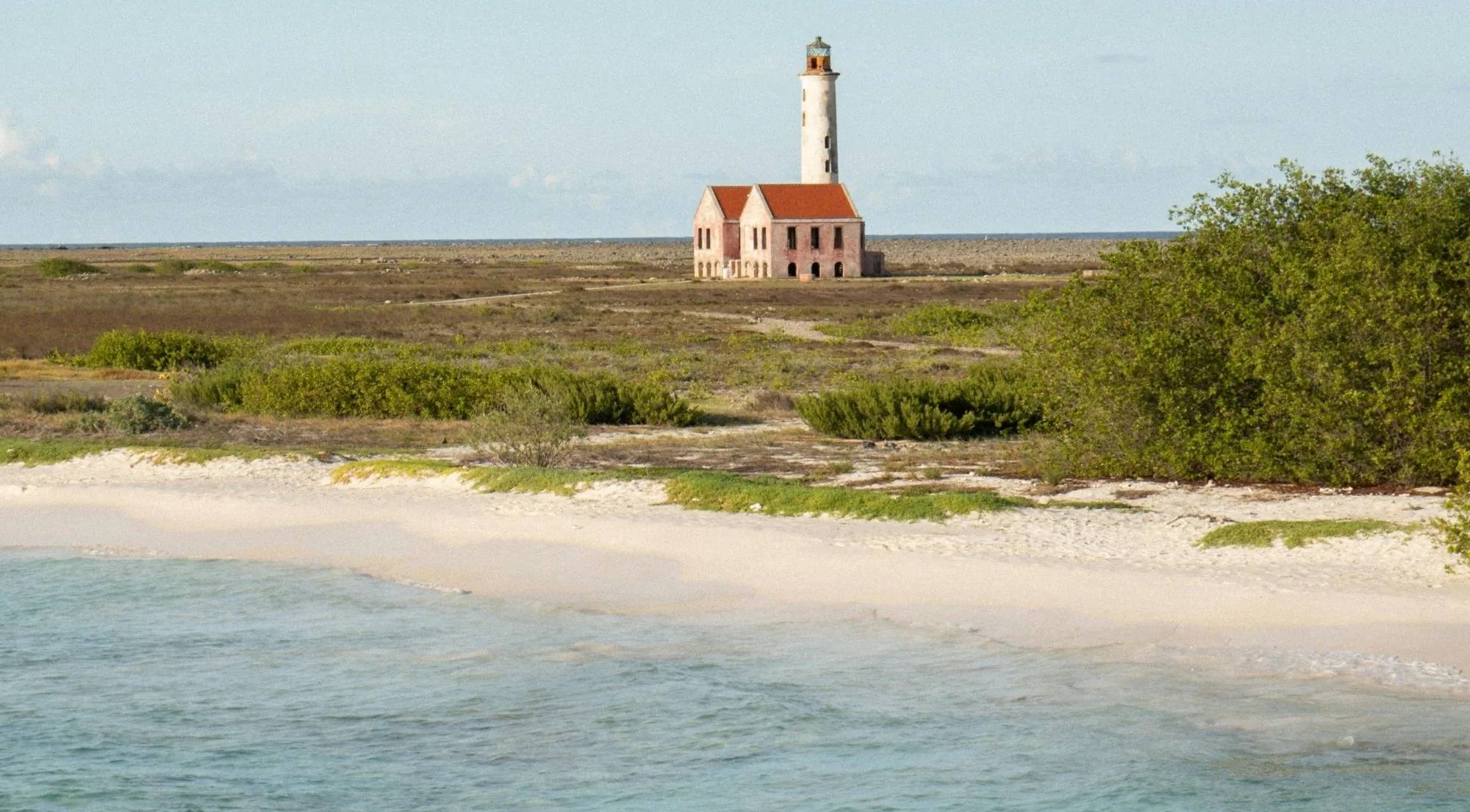 Klein Curaçao's lighthouse and keeper's house seen across the scrub from the anchorage