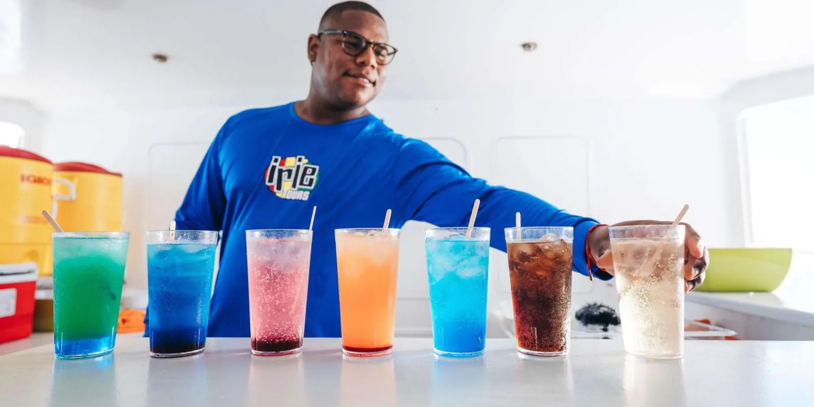 An Irie Tours crew member with the open bar's drinks lined up on the counter