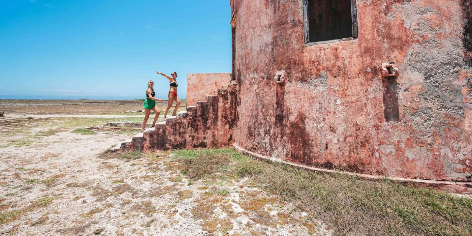 Visitors at the weathered wall of Klein Curacao's lighthouse keeper's house