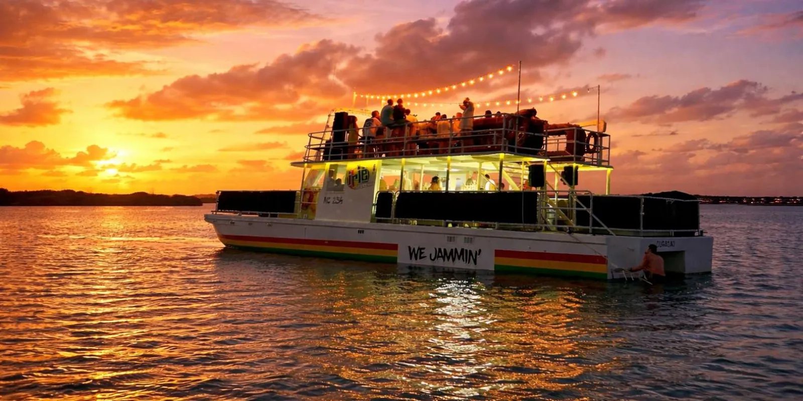 The Irie Tours catamaran lit up on Spanish Water at sunset