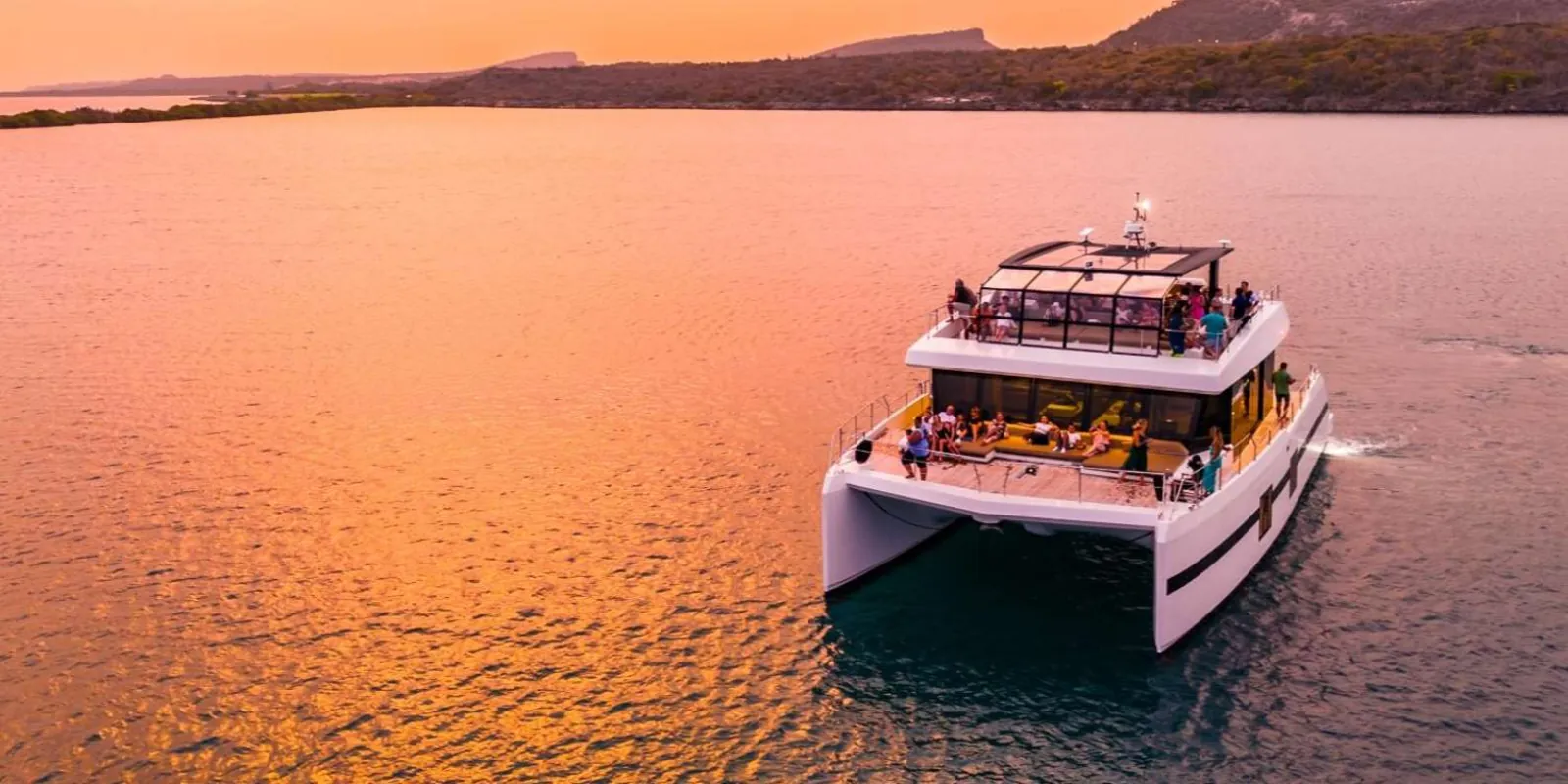 Aerial view of the catamaran on a pink evening sea off Curacao's south coast