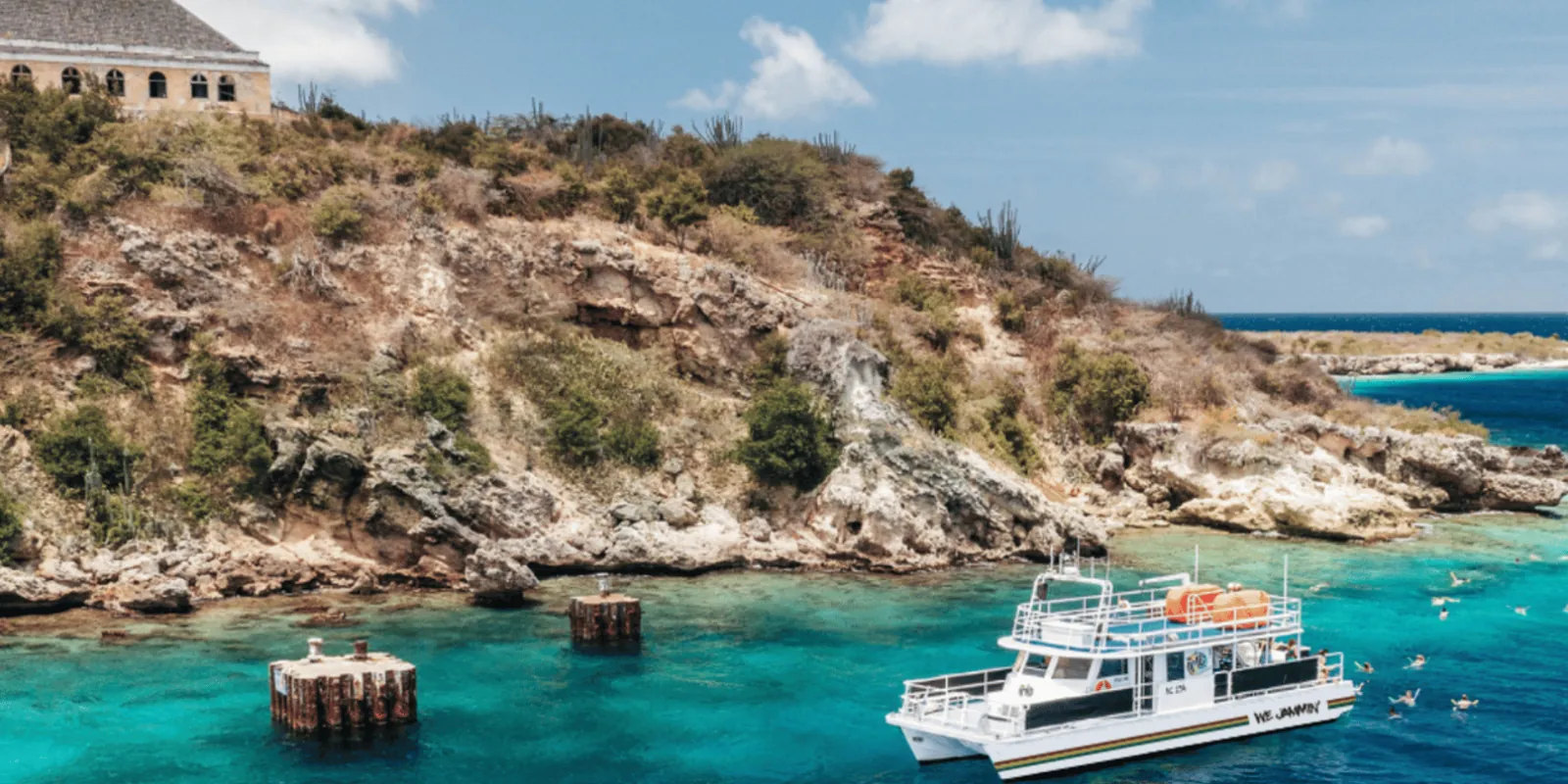 The Irie Tours catamaran moored beside the pier at Tugboat Beach, Caracas Bay